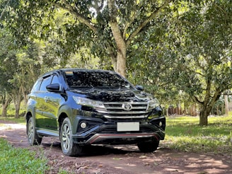 a black suv parked on a dirt road