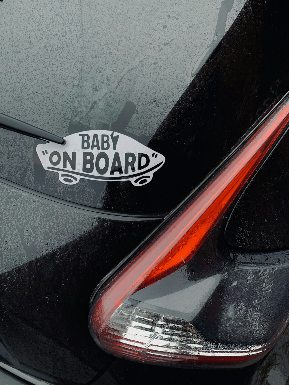 a close up of a car with a baby on board sticker on it