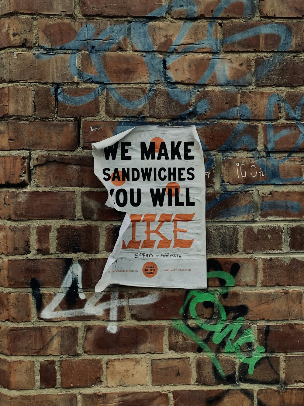 a sign on a brick wall that says we make sandwiches you will like