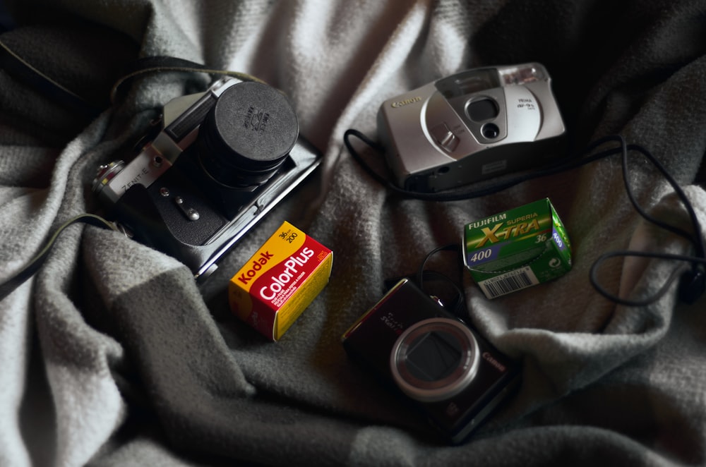 a couple of cameras sitting on top of a blanket