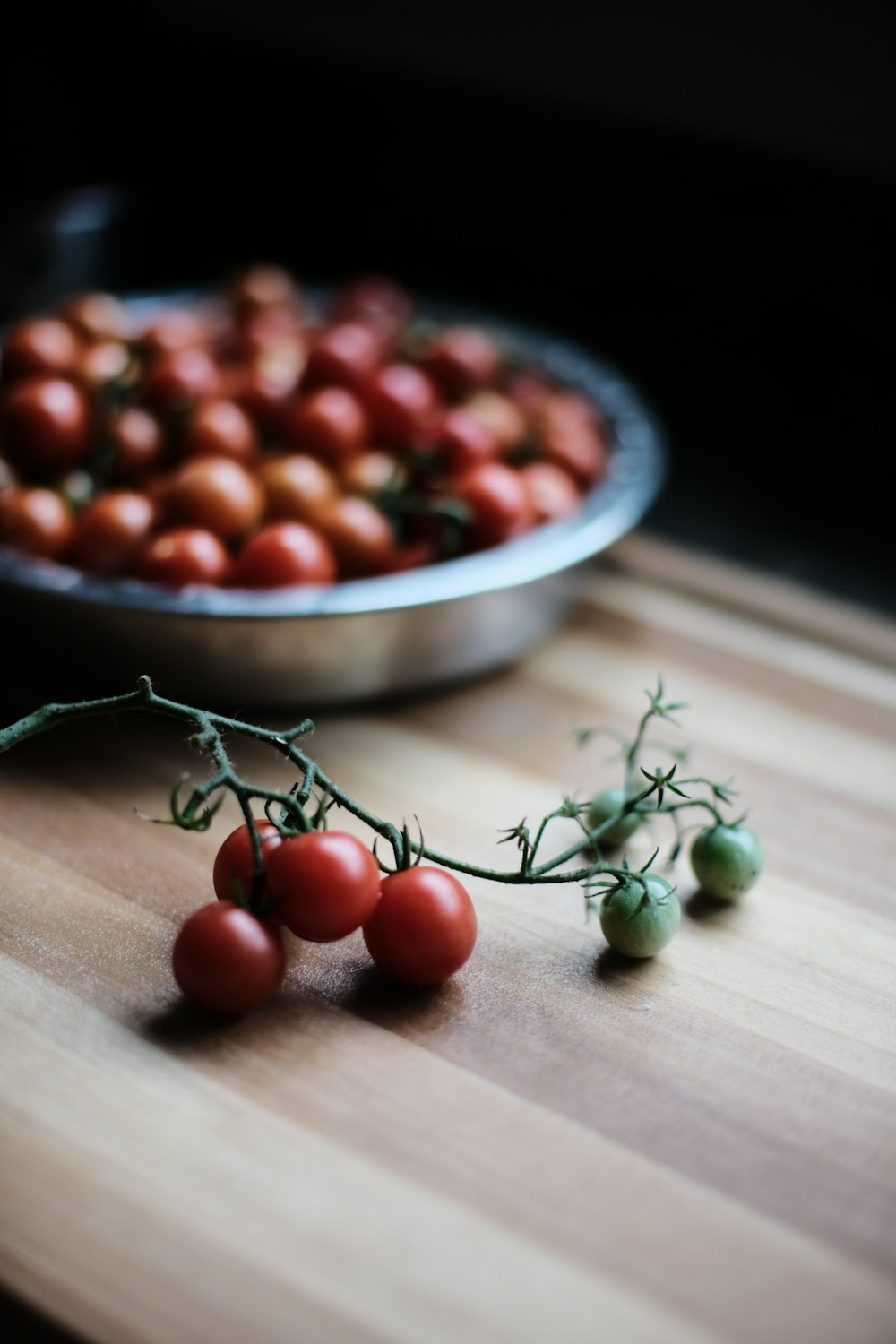 a close up of a bowl of tomatoes on a table
