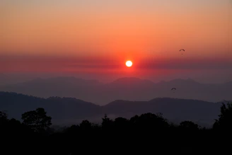 A panoramic photo capturing the vibrant sunset over Fethiye as seen from a paraglider's perspective.