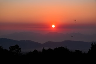 A vibrant sunset view over Mandar Parvat with pilgrims ascending the spiritual hill.