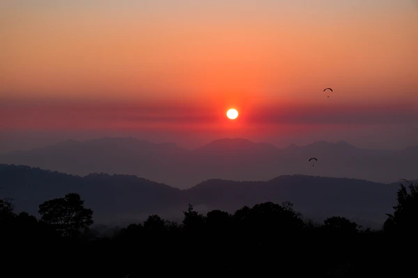 A panoramic photo capturing the vibrant sunset over Fethiye as seen from a paraglider's perspective.