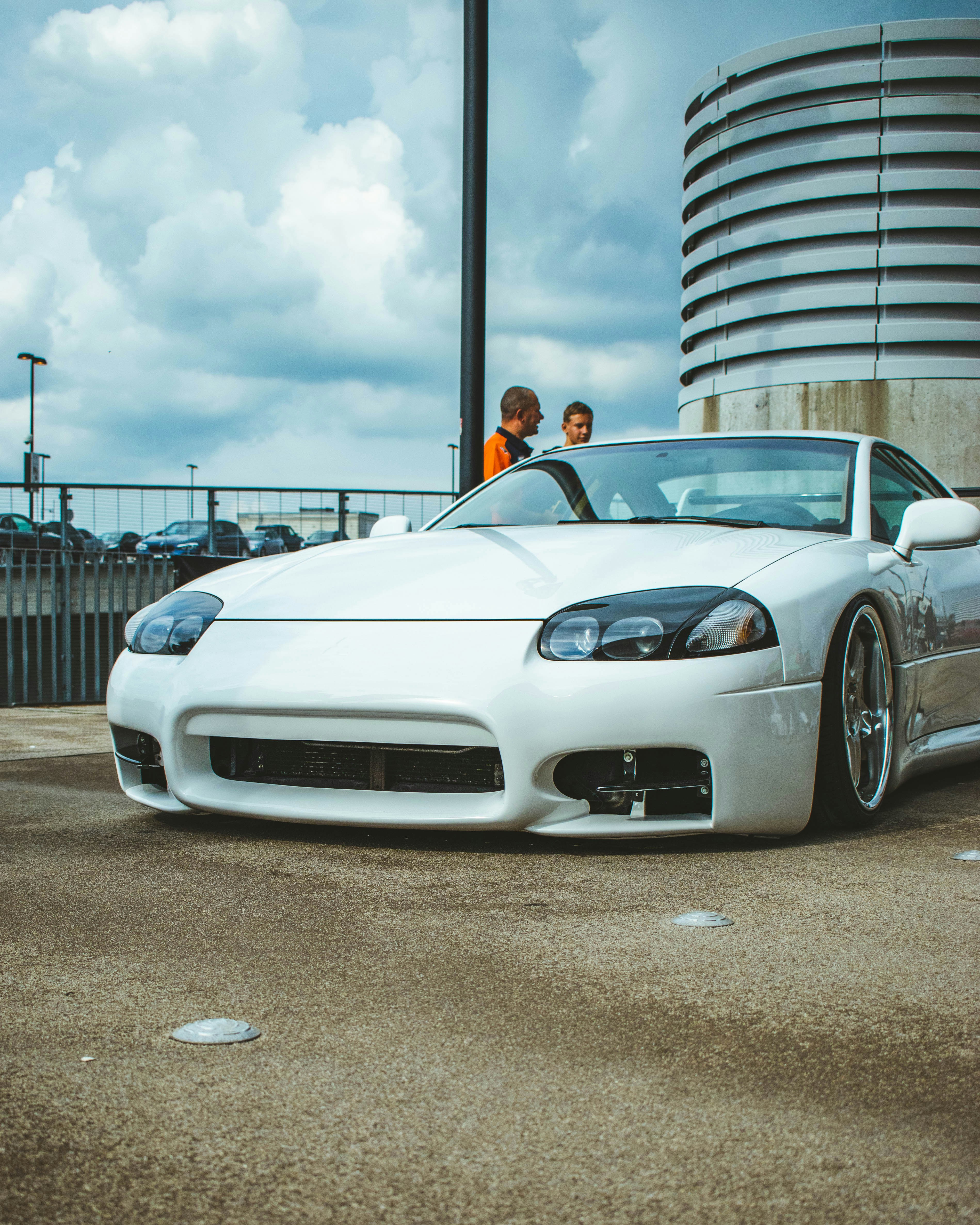 a white sports car parked in front of a tall building