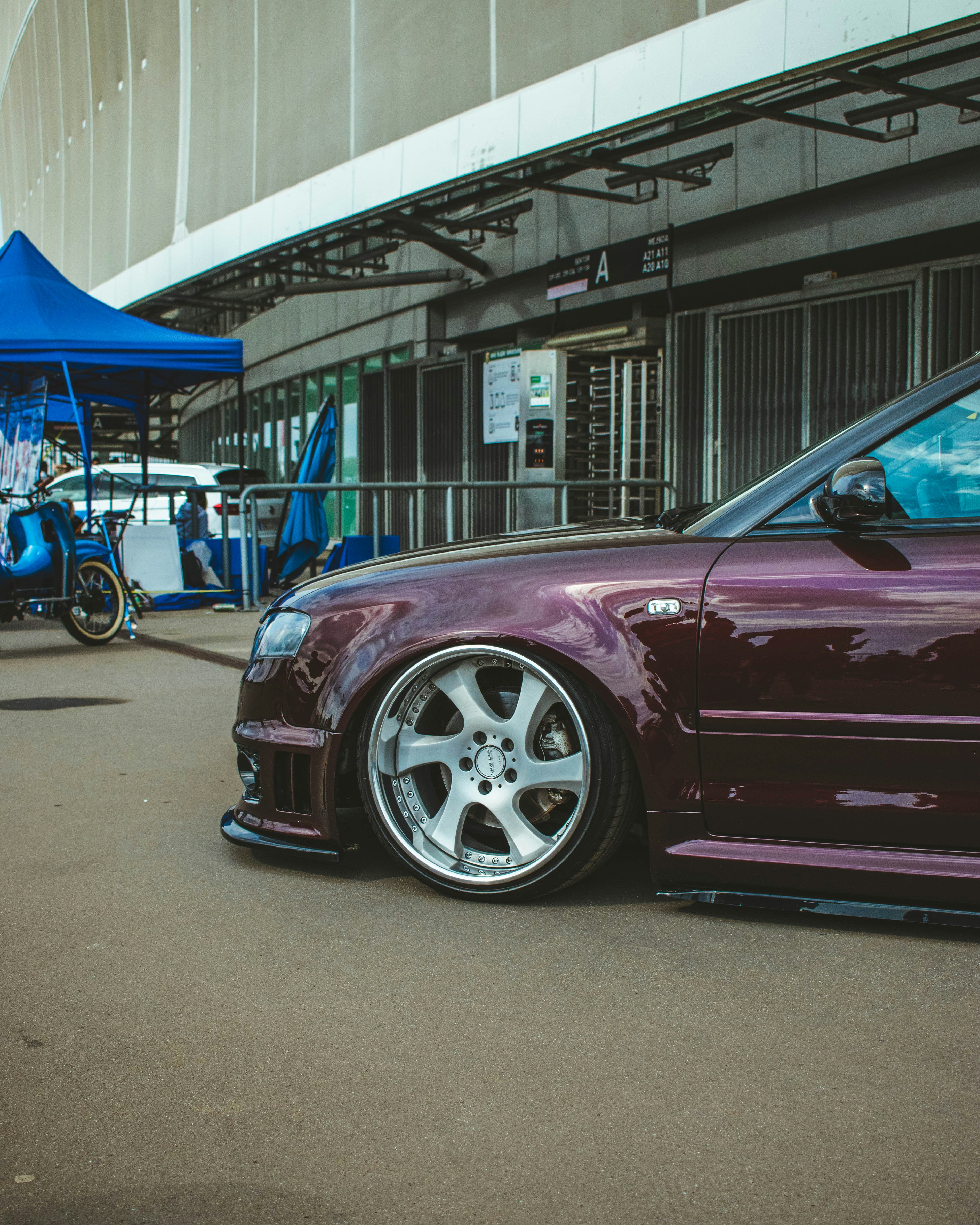 a purple sports car parked in front of a building