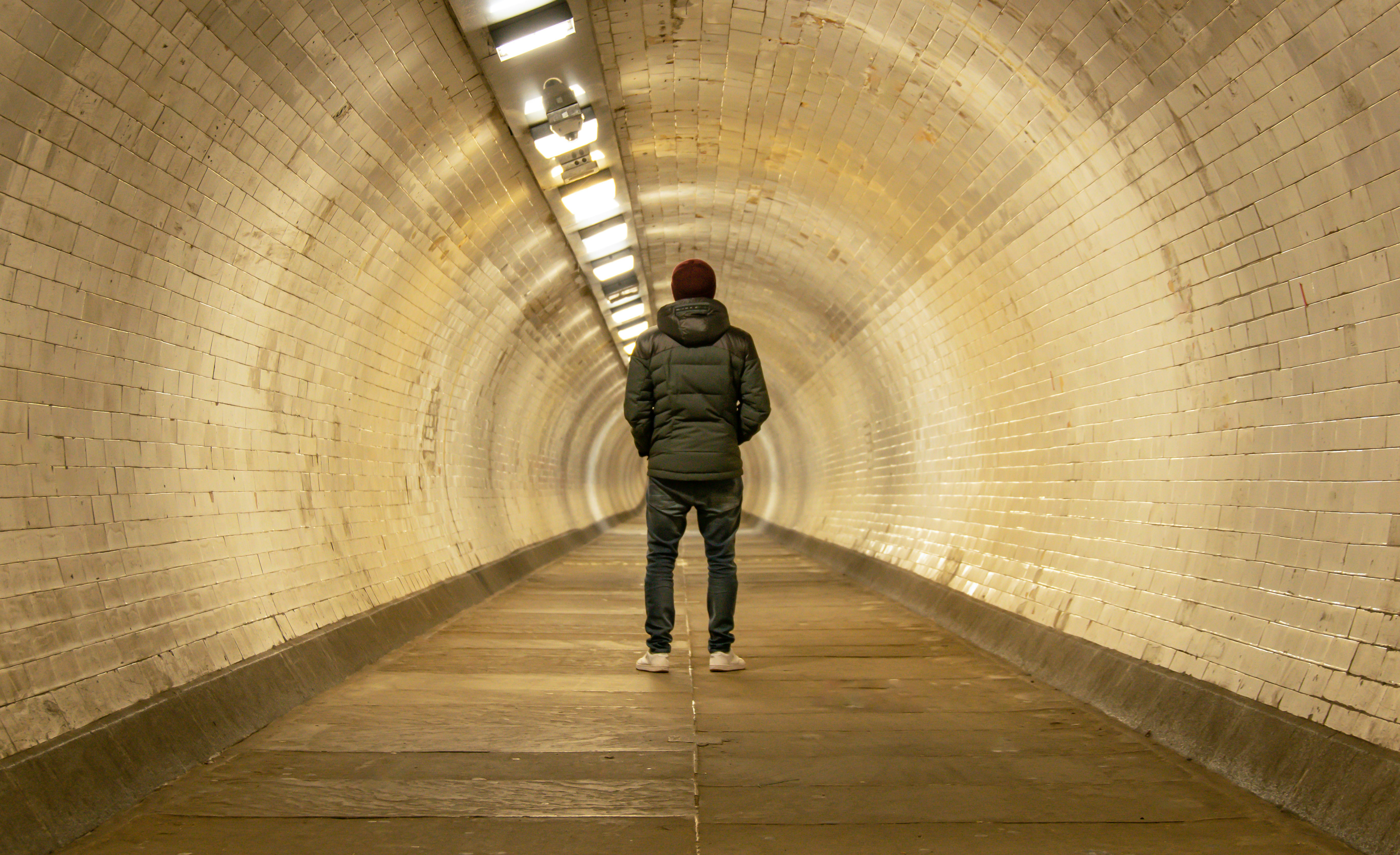 a man is standing in the middle of a tunnel, 