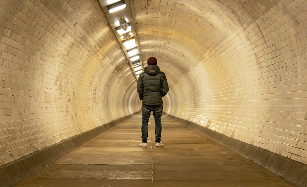 a man is standing in the middle of a tunnel