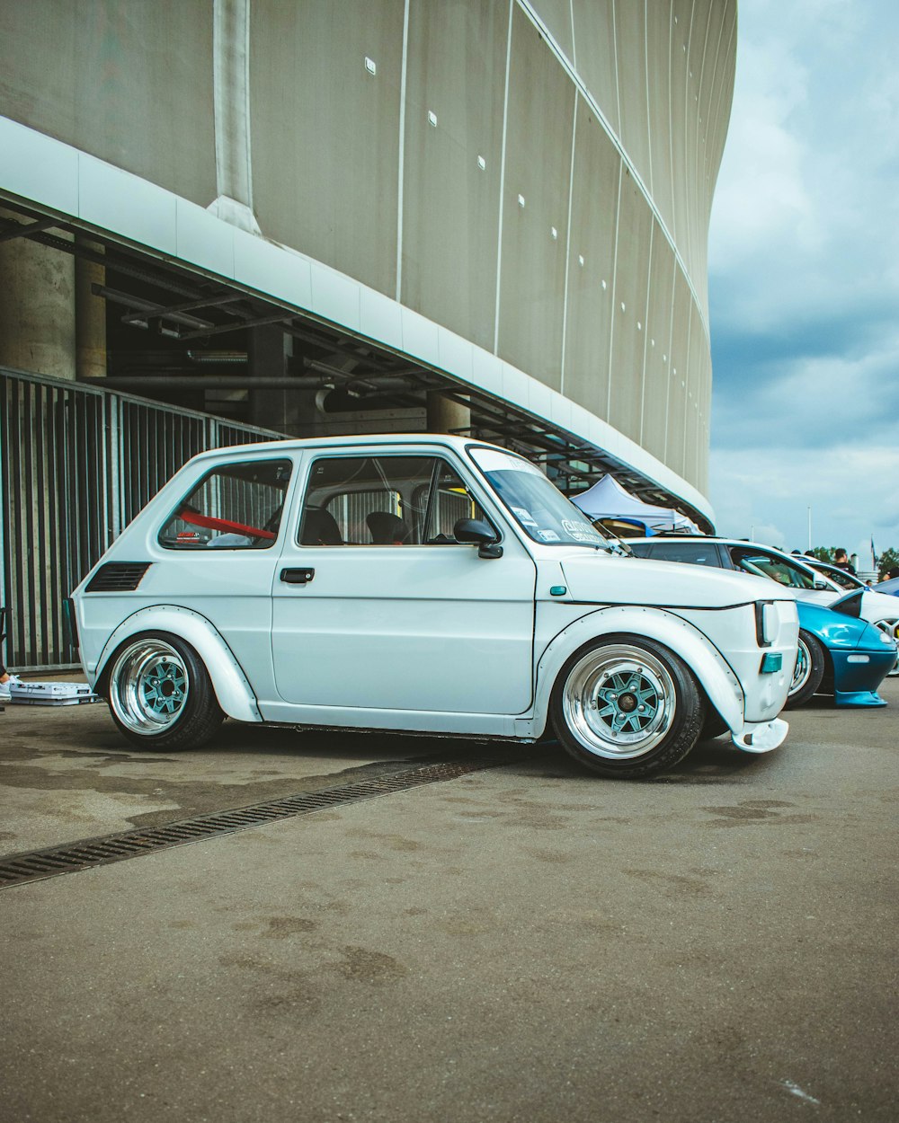 a small white car parked in front of a building