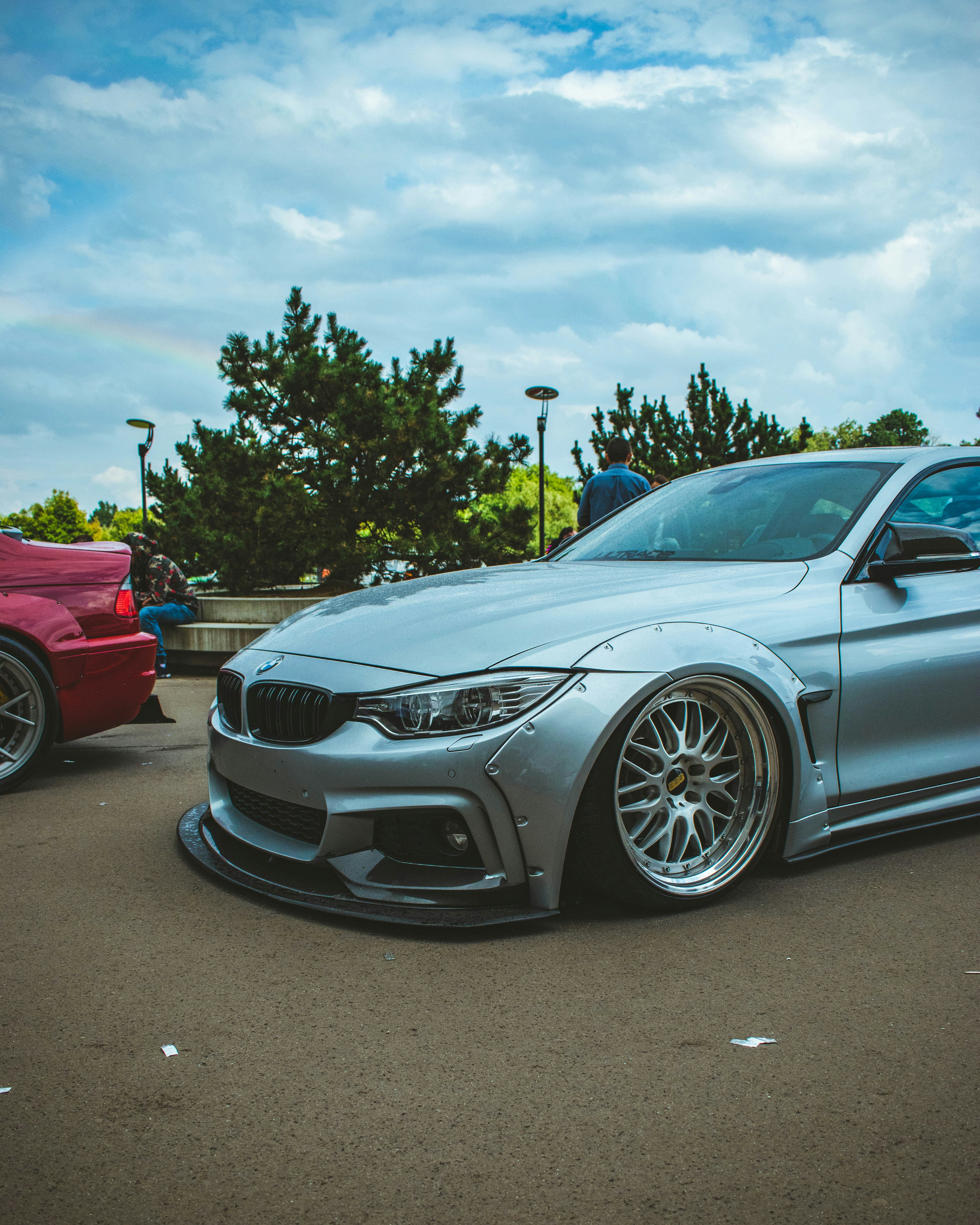 a silver car parked in a parking lot next to another car