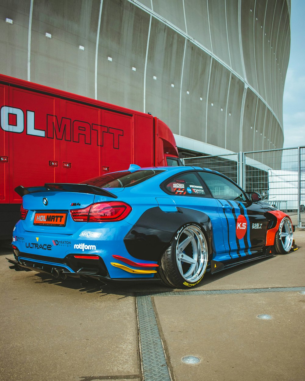 a blue car parked in front of a red truck