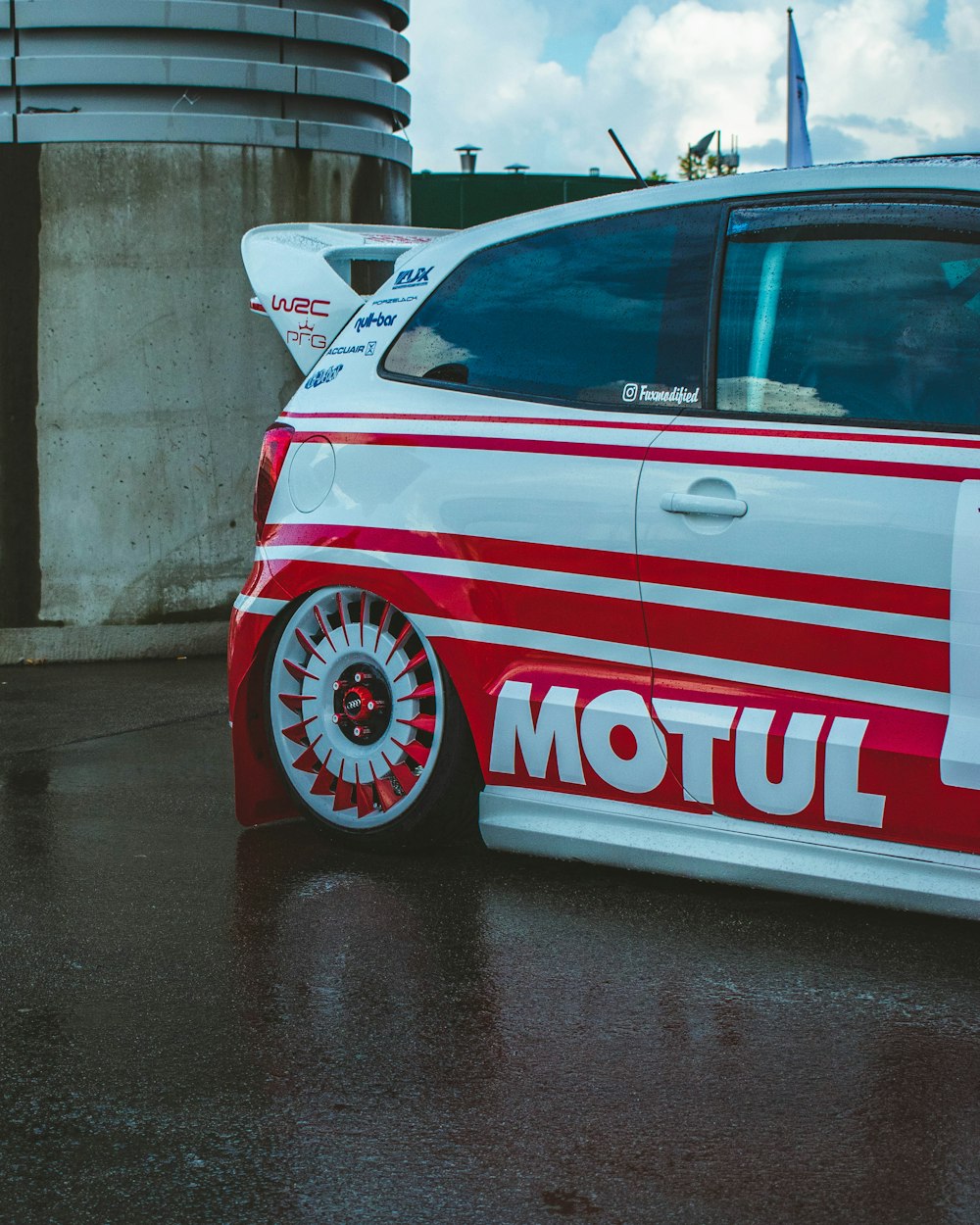 a red and white car parked in a parking lot