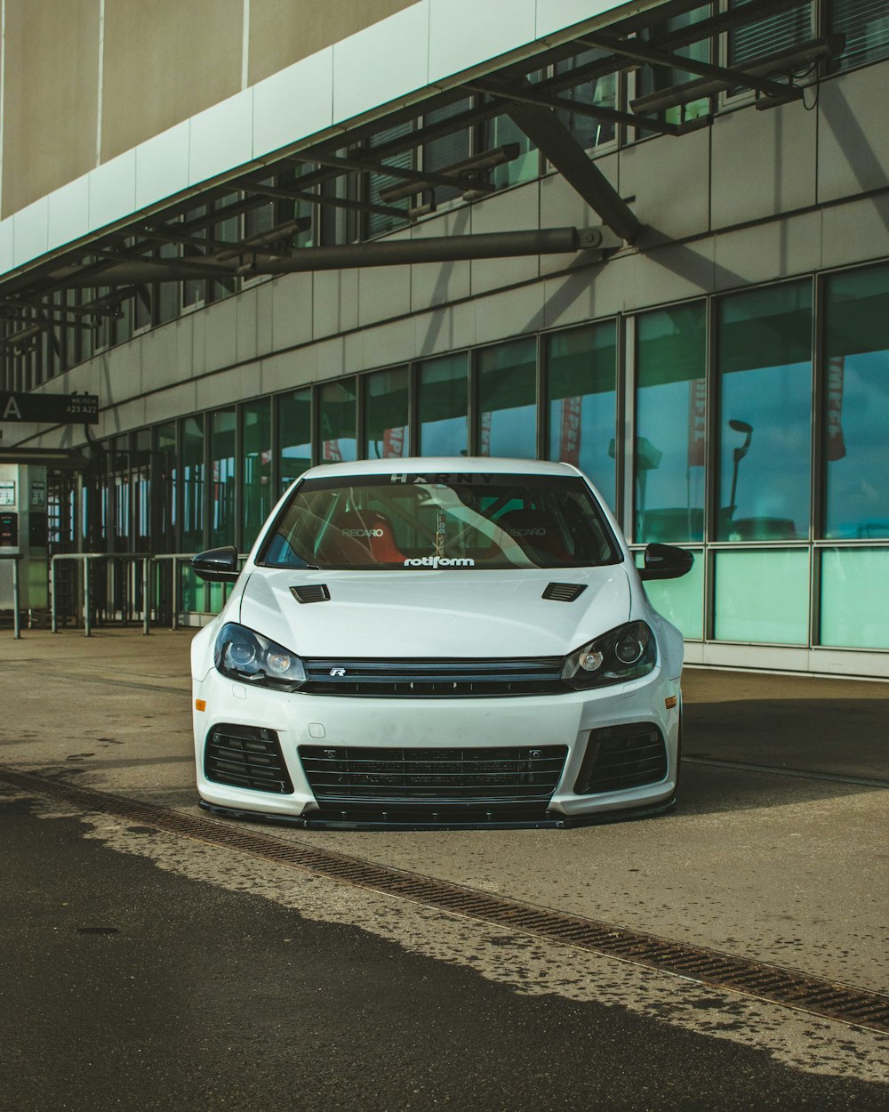 a white car parked in front of a building