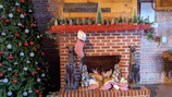 Traditional brick fireplace decorated with seasonal ornaments.