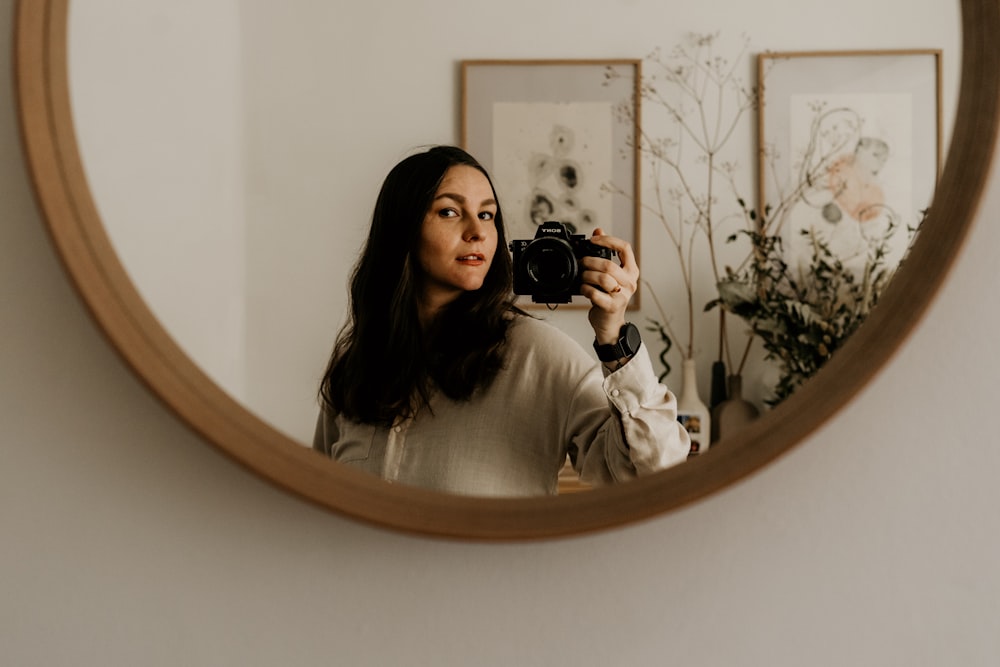 a woman taking a picture of herself in a mirror