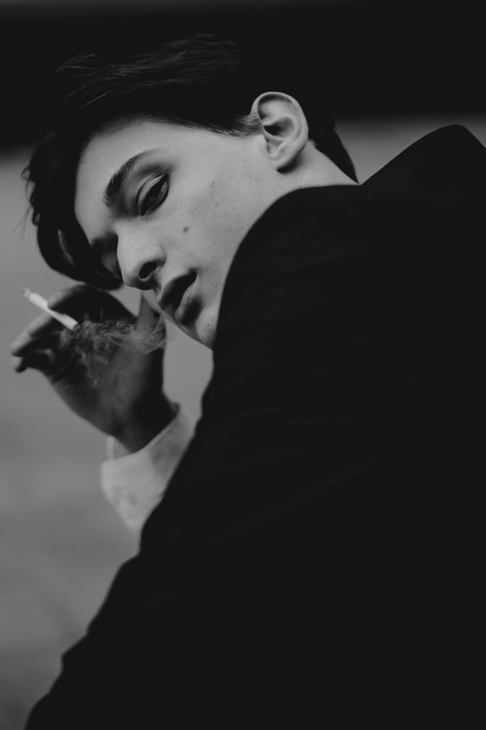 a black and white photo of a man smoking a cigarette