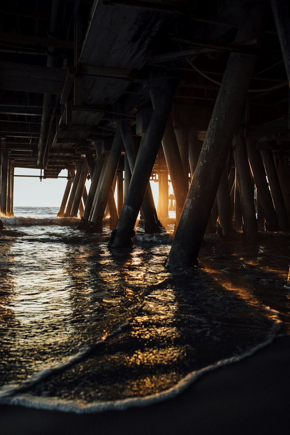 a view of the ocean under a pier
