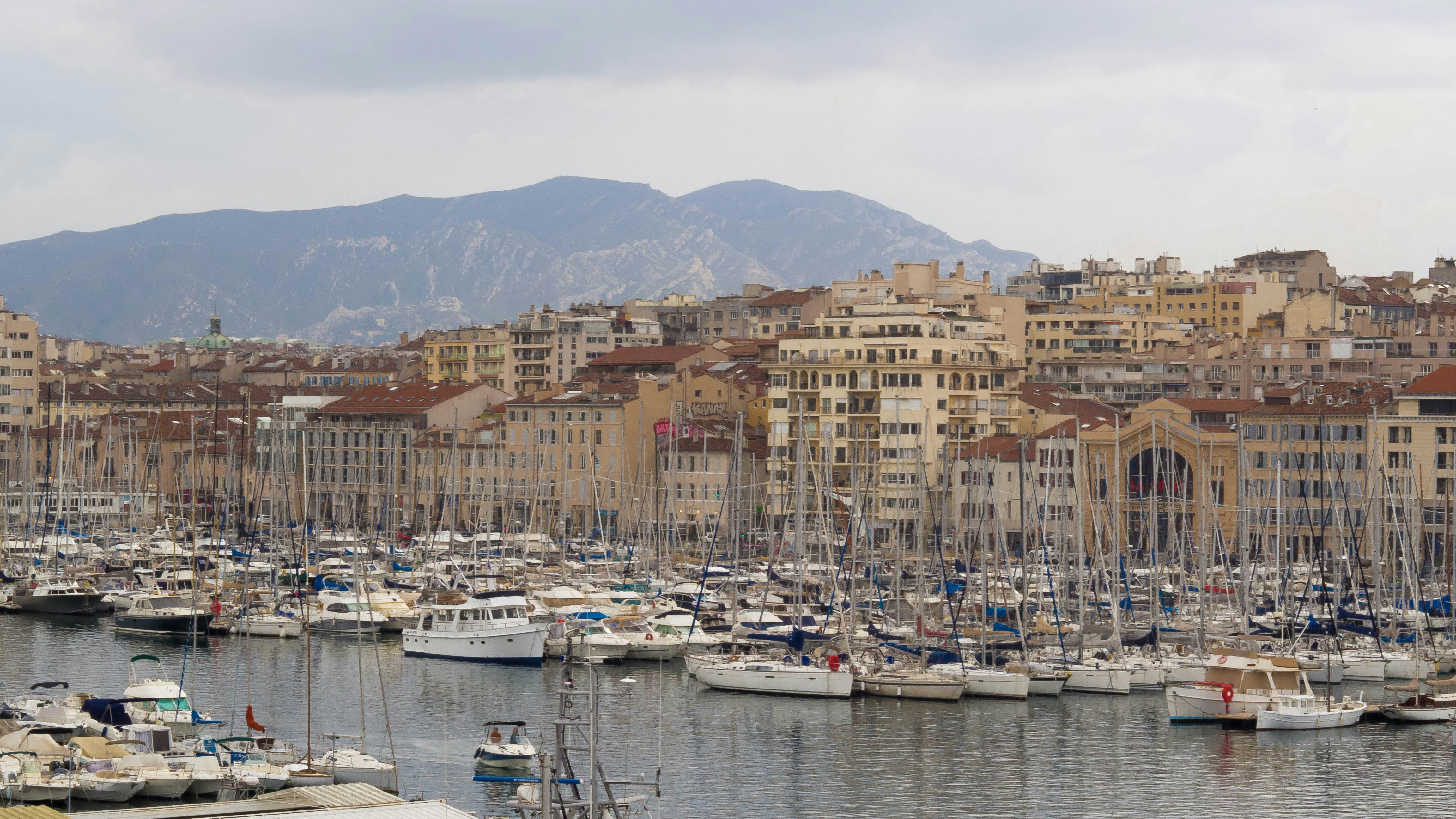 a harbor filled with lots of boats next to tall buildings