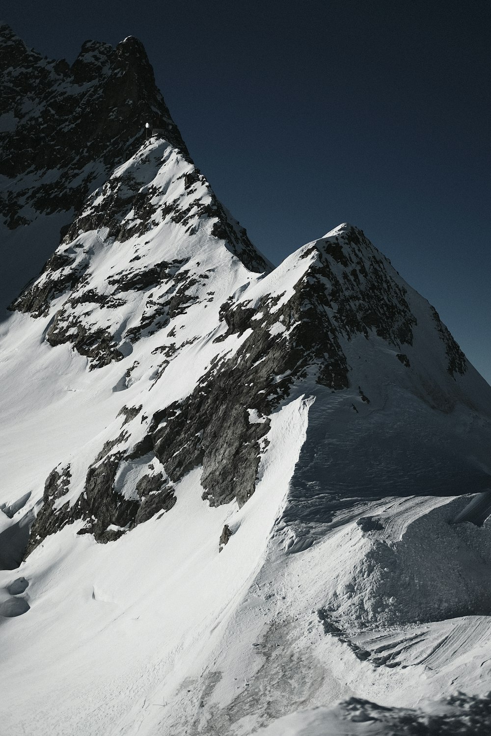 a man riding skis down the side of a snow covered mountain