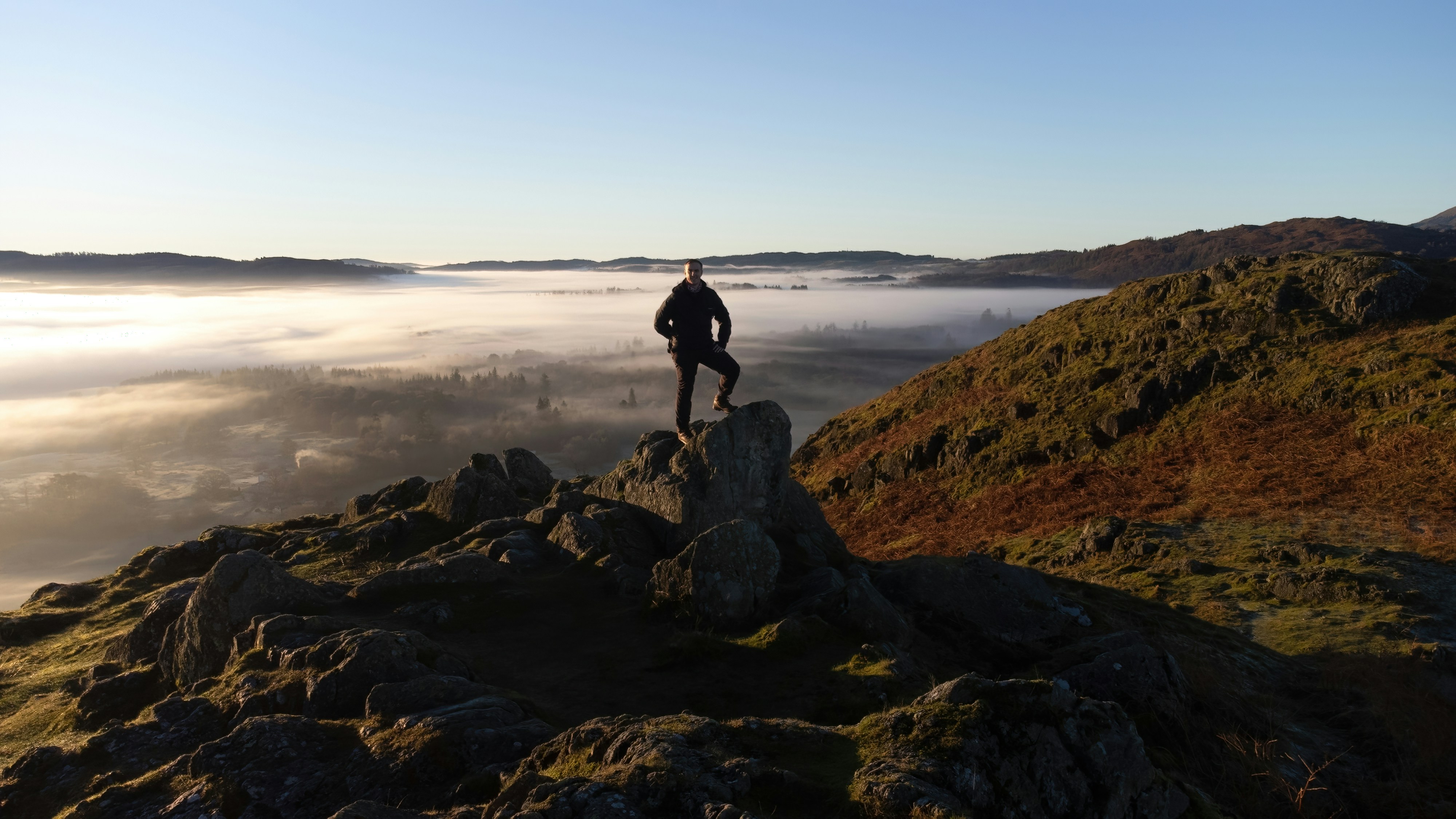 a man standing on a rocky hill, 