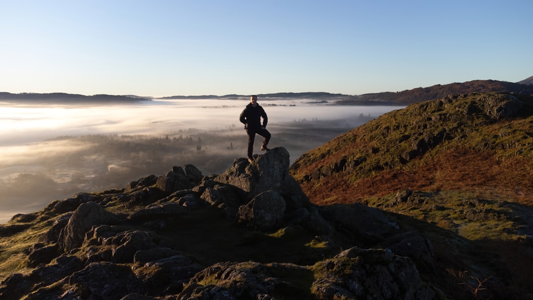 a man standing on a rocky hill,