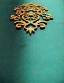 A delicate layered wood art piece featuring soft curves and teal accents.