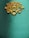 An ornate, symmetrical wooden decoration with intricate patterns sits on a textured teal background. The design features swirling lines and curves, giving it an elegant and artistic appearance.