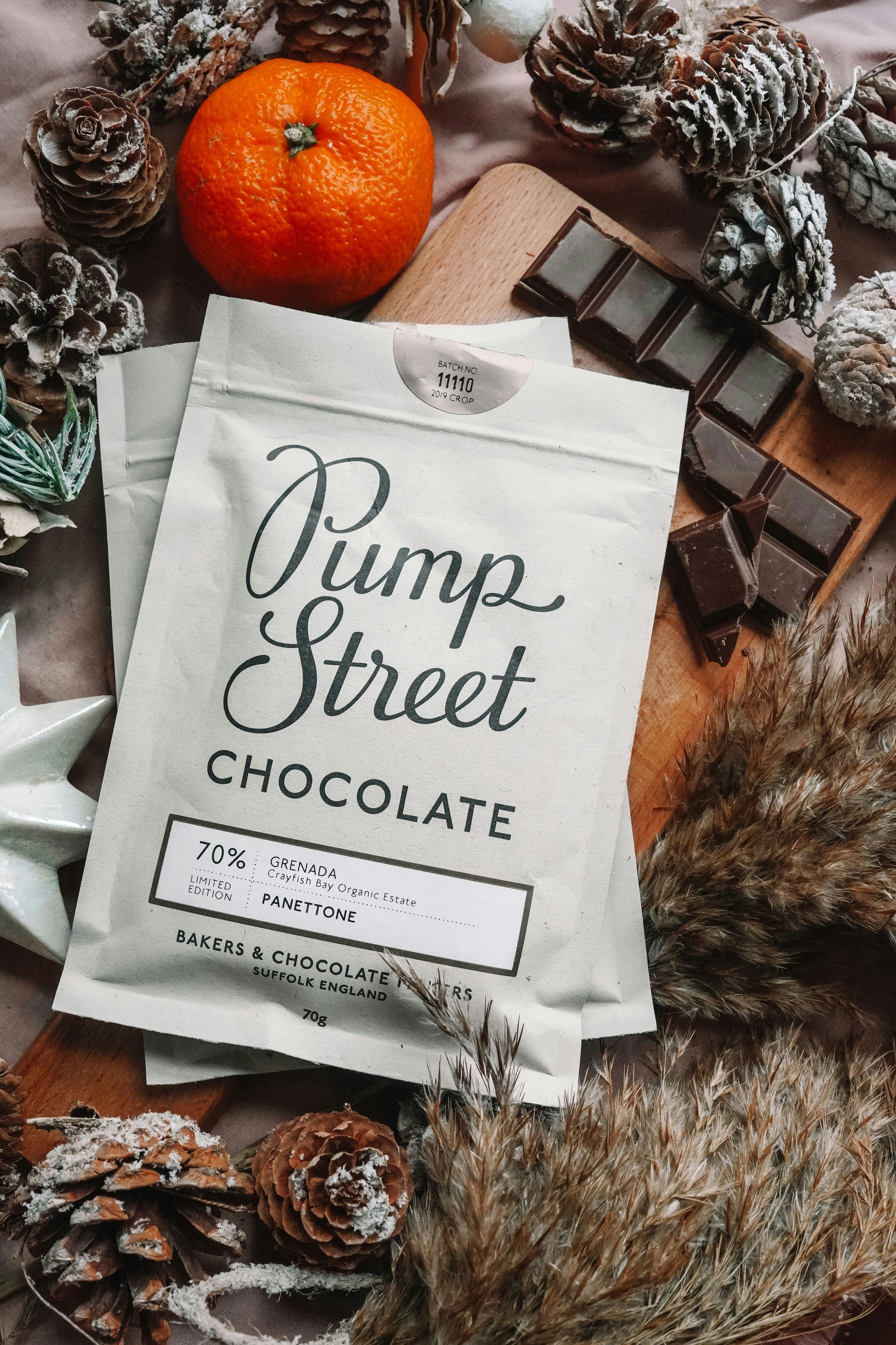 um saco de chocolate de rua de abóbora ao lado de uma pilha de pinhas