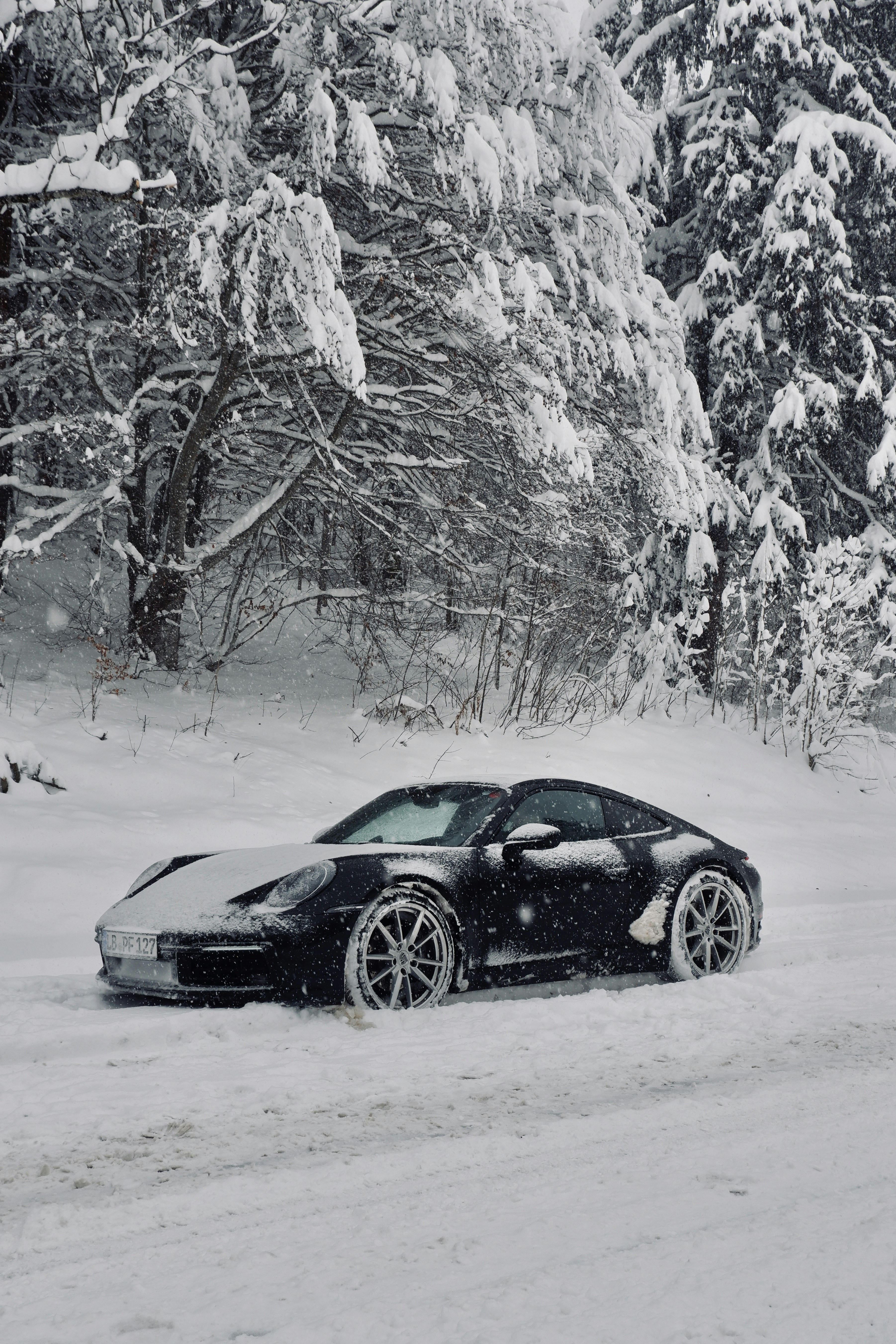 A black car driving down a snow covered road photo – Free Grey Image on ...