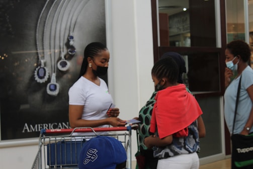 a woman standing next to a child in a shopping cart