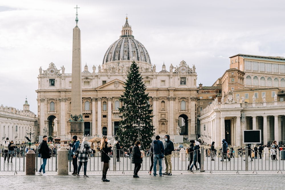 a group of people standing around a christmas tree