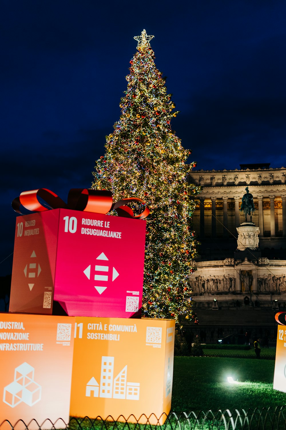 a large christmas tree in front of a building