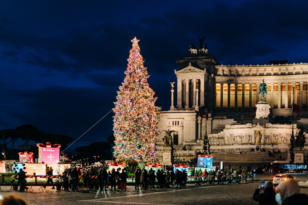 a large christmas tree in front of a building