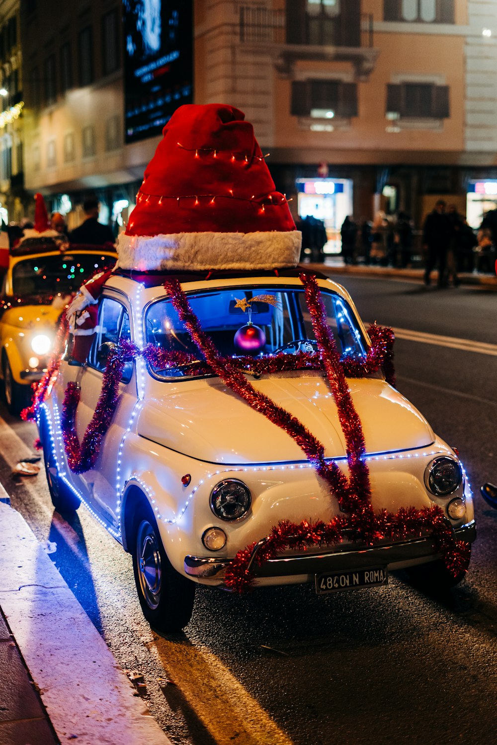 Ein Auto mit einem Weihnachtshut oben drauf, fährt die Straße entlang