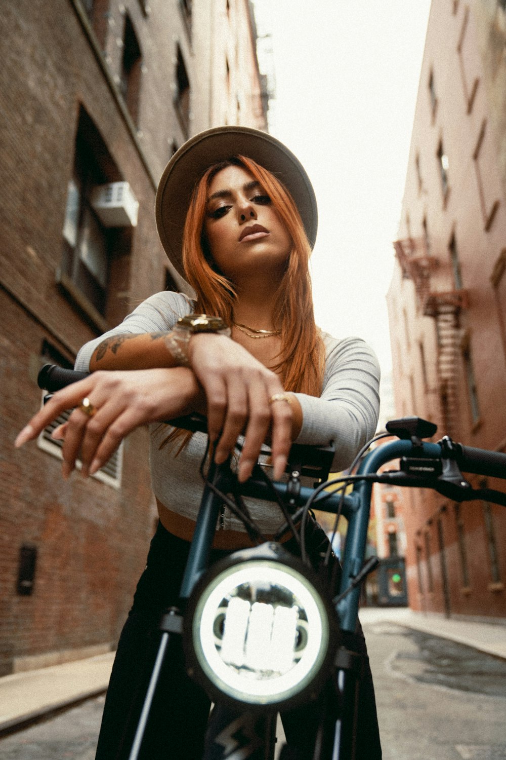 a woman with red hair is standing next to a bicycle