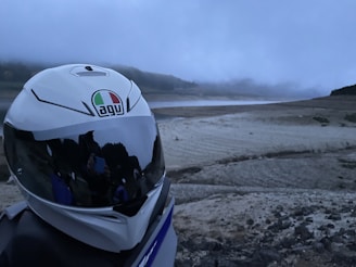 A rugged mountain bike helmet covered in dust, placed on a rocky trail.