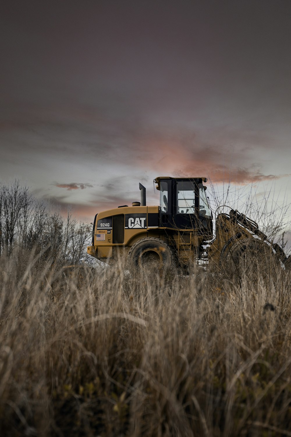 a bulldozer is parked in a field of tall grass