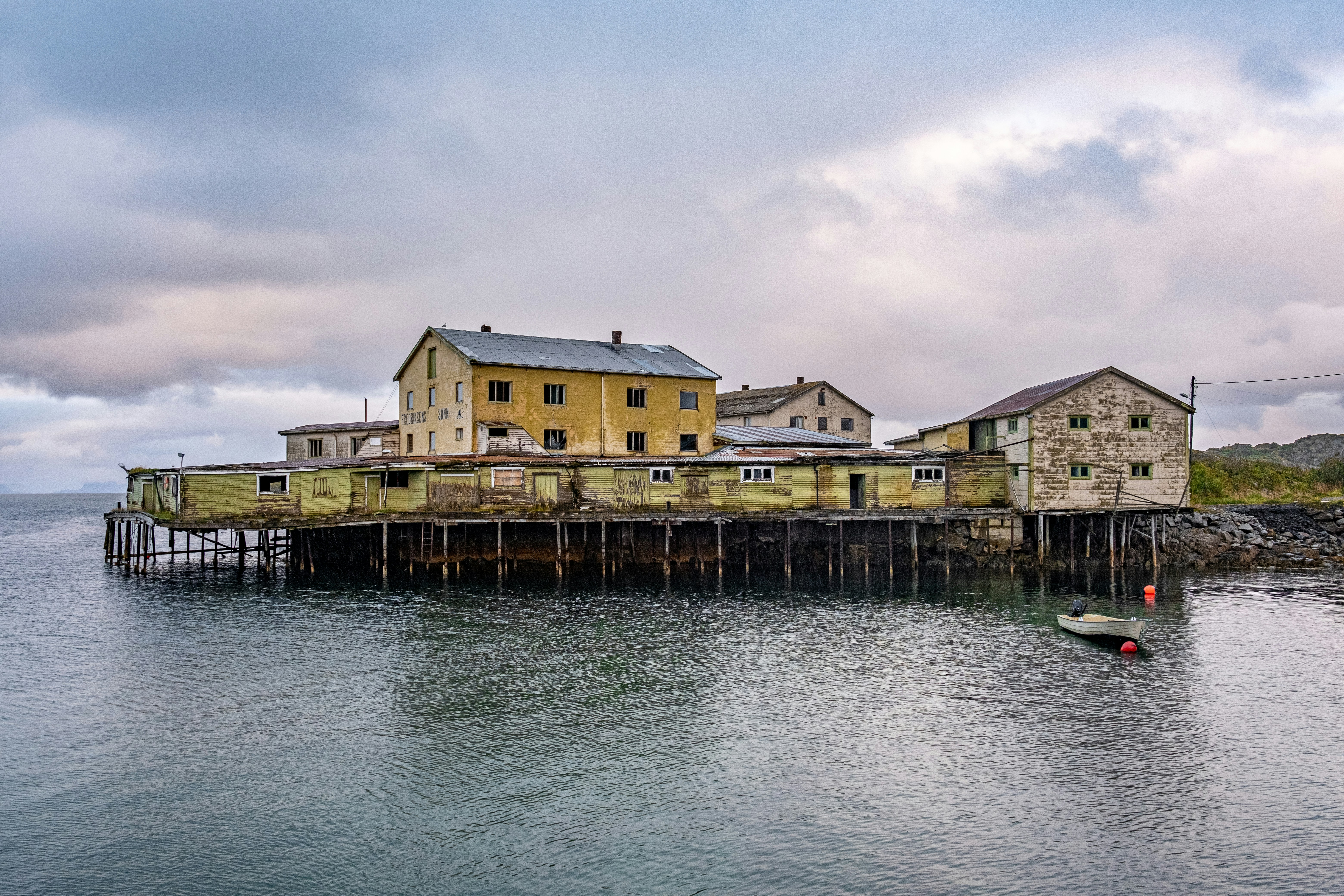 a house sitting on top of a pier next to a body of water