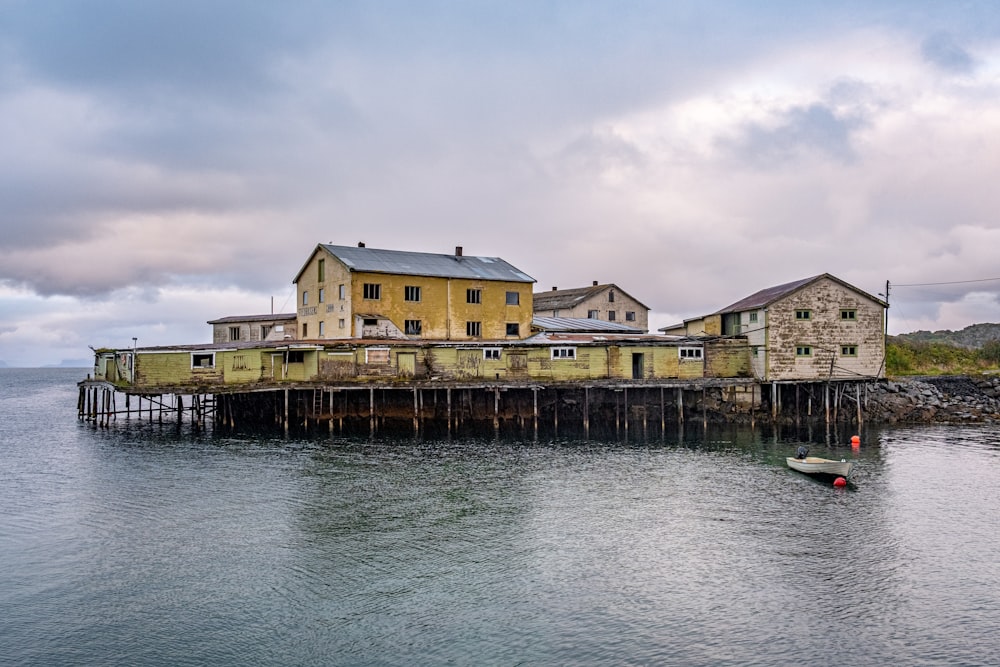 a house sitting on top of a pier next to a body of water