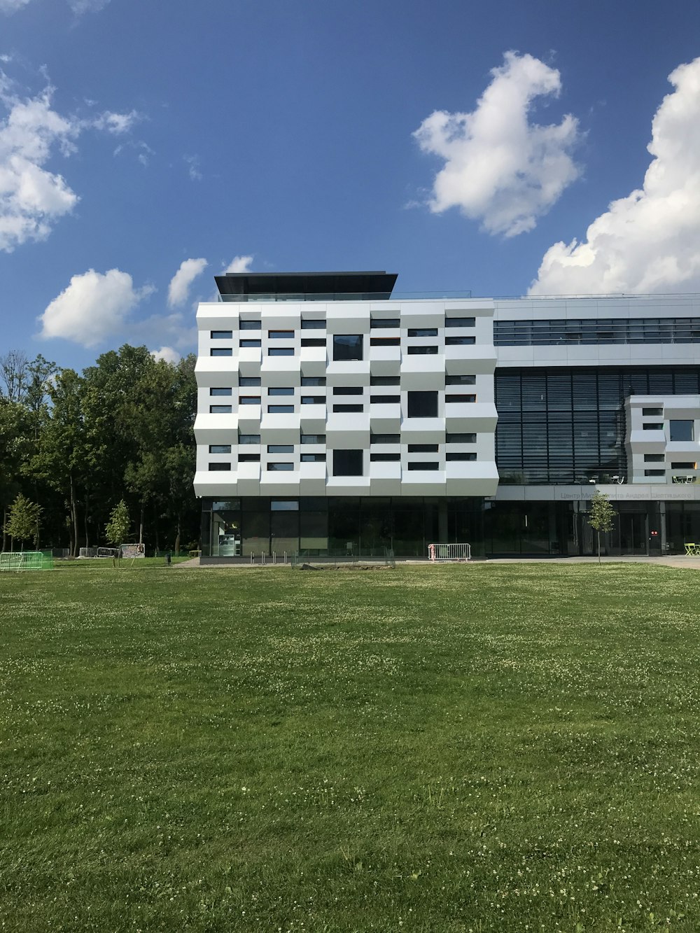 a large white building sitting on top of a lush green field