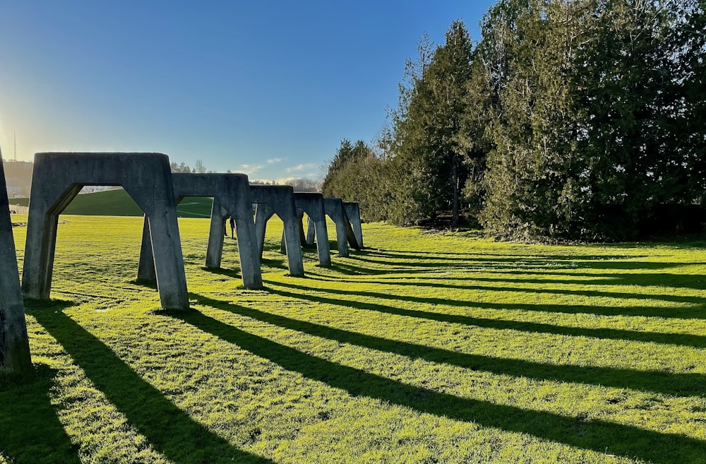 a row of concrete structures sitting on top of a lush green field
