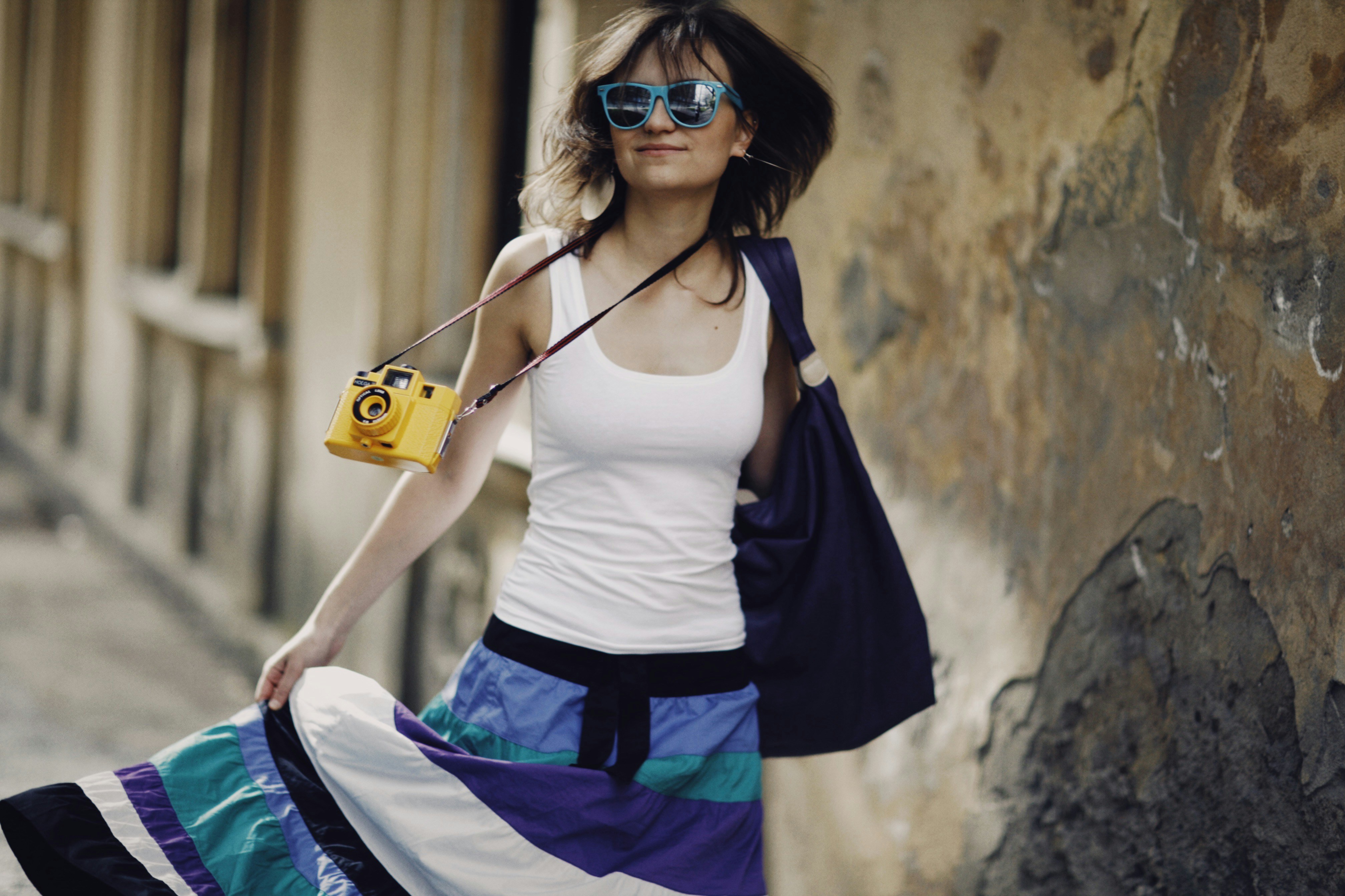 a woman with a camera is walking down the street