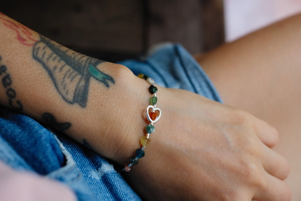 a person wearing a bracelet with a heart on it