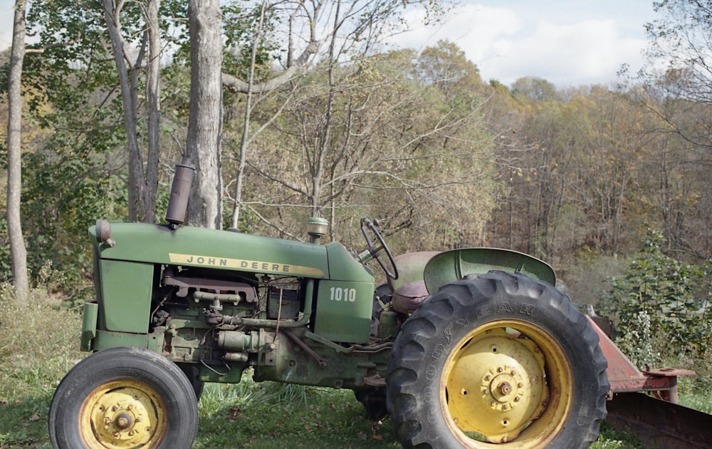an old green tractor parked in a field