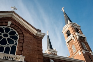 a church with two steeples and a cross on top