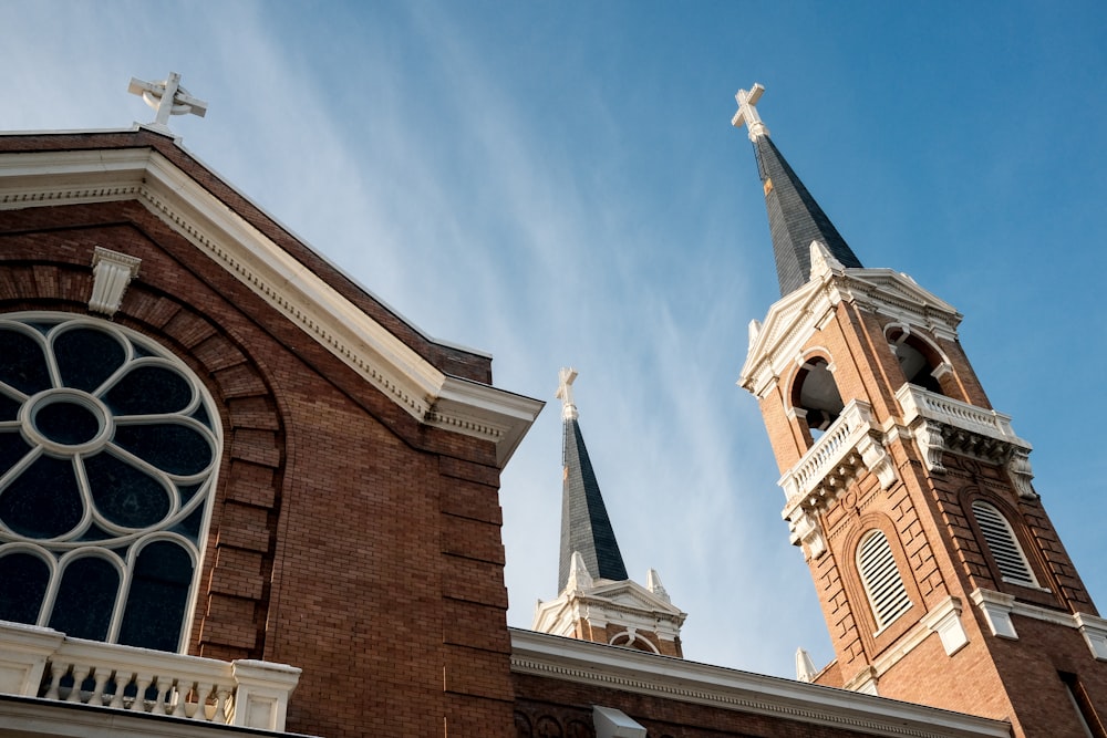 a church with two steeples and a cross on top