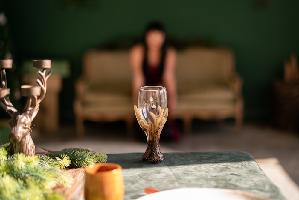 a woman sitting on a couch next to a table with a wine glass on it