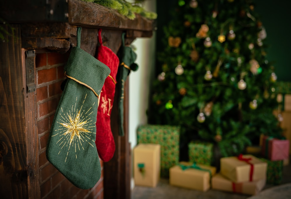 Una media navideña colgando de una chimenea junto a un árbol de Navidad