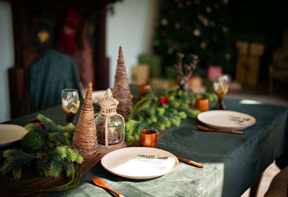 a table set for christmas with plates and candles