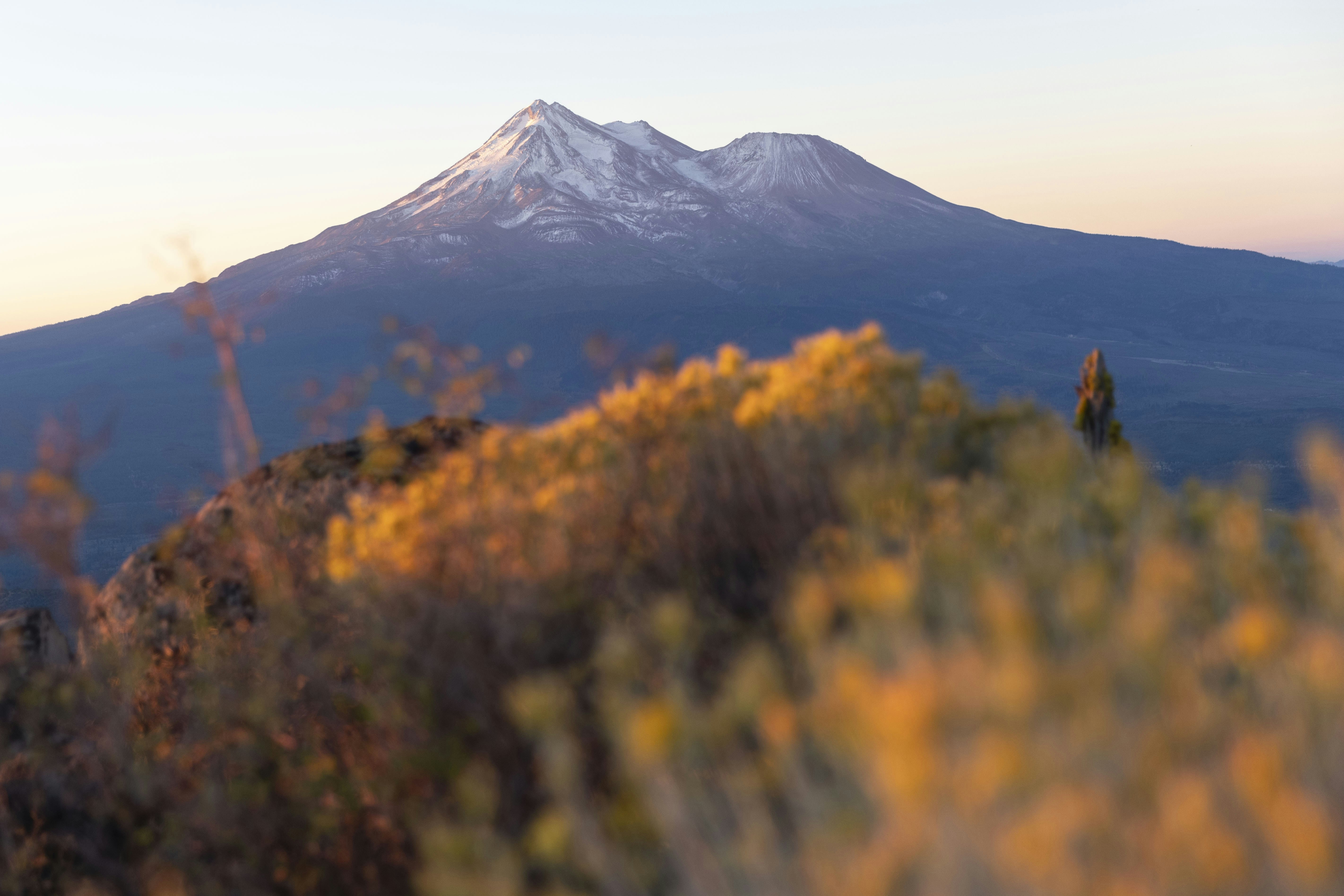 a view of a snow capped mountain from the top of a hill, adventure travel